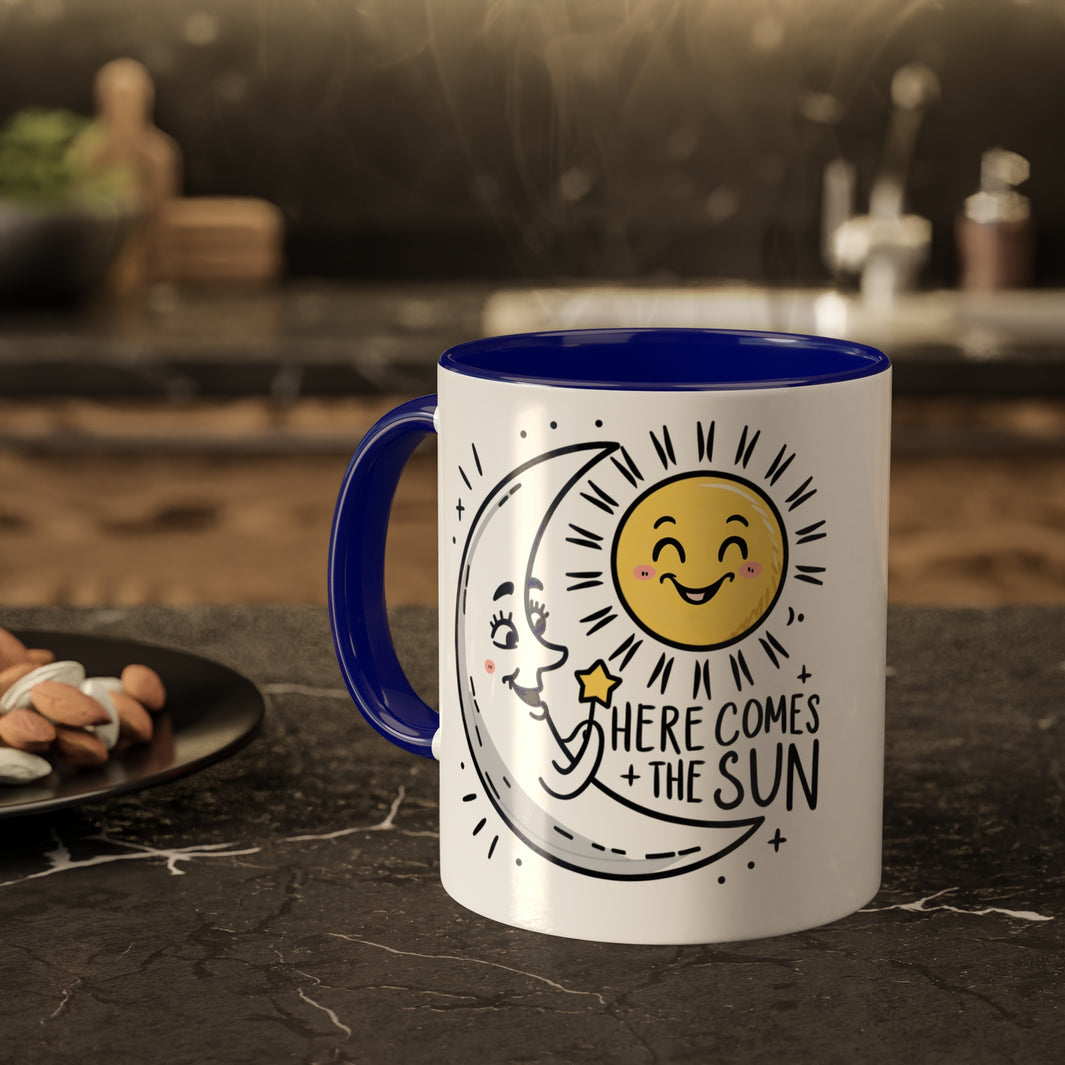 the happy cresent moon greet the rising sun on a mug with the slogan here comes the sun