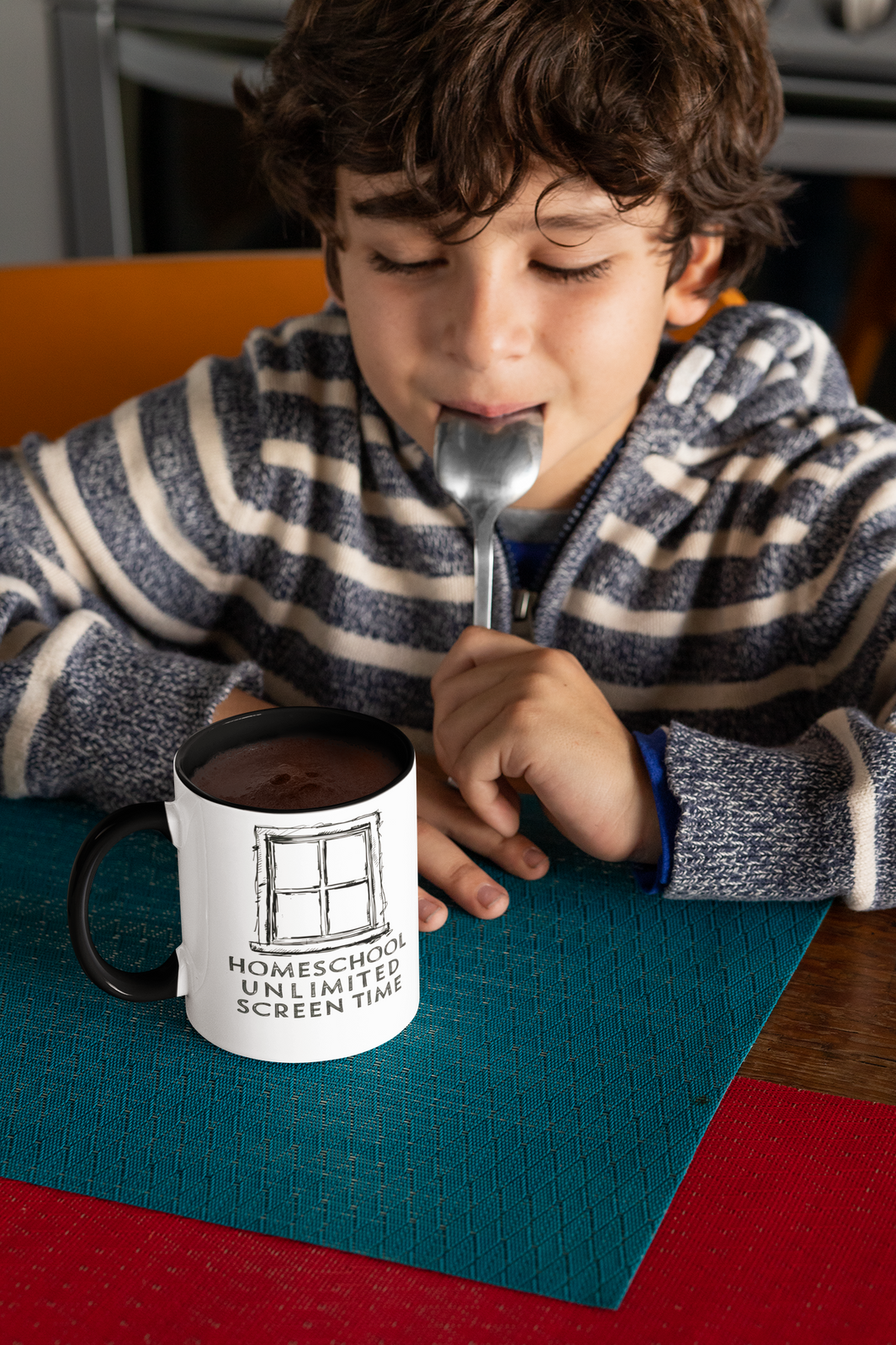 a boy enjoying hot cocoa from his homeschool mug on the mug a window frame with the slogan homeschool unlimited screen time