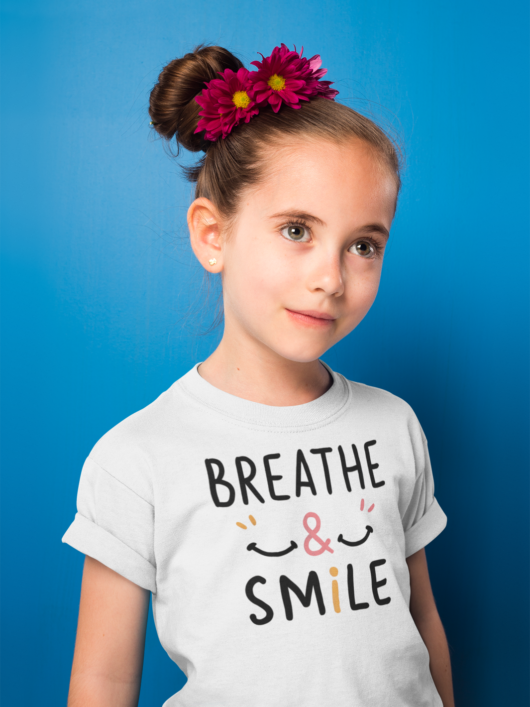 a happy girl wearing a t-shirt with the caption Breathe & Smile. two smile faces adore the caption